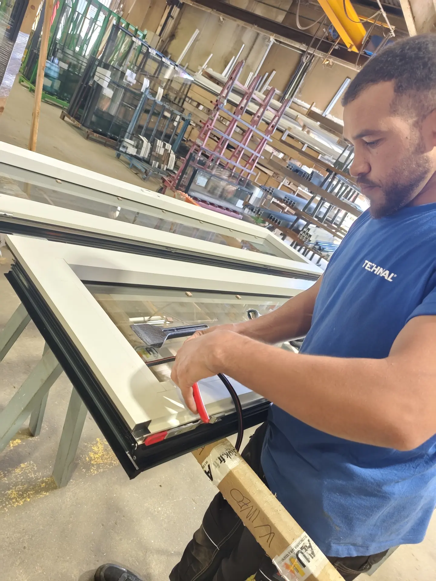 Pose d'un vitrage sur une menuiserie en atelier Wineo France